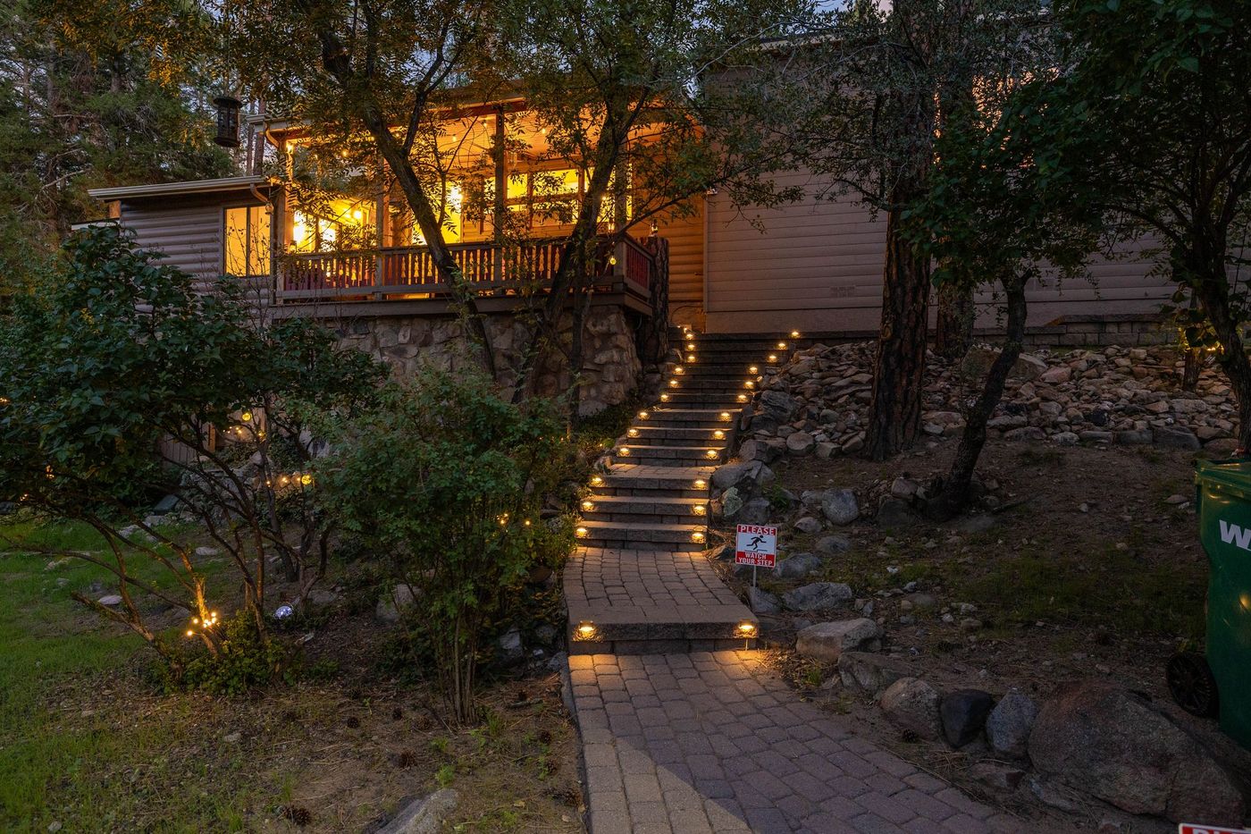 The Treehouse at twilight, warm lights glowing through the pines